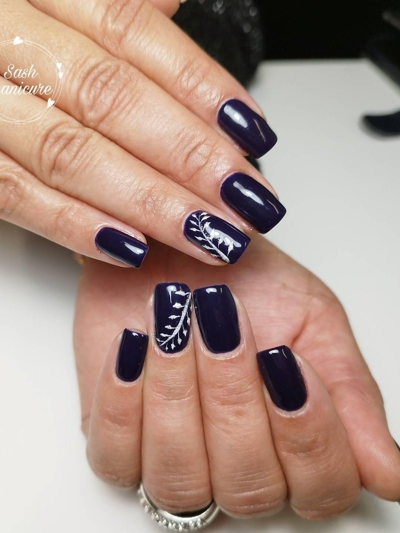 Donkerblauwe nagels met een witte bladtekening